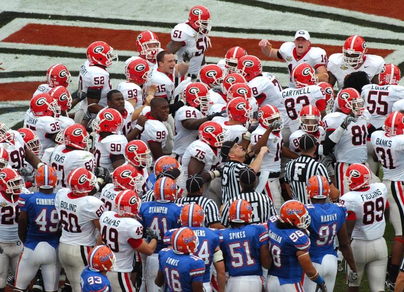 Georgia players swarm onto the field after scoring the first touchdown of the game. (DAVID TULIS / Staff)