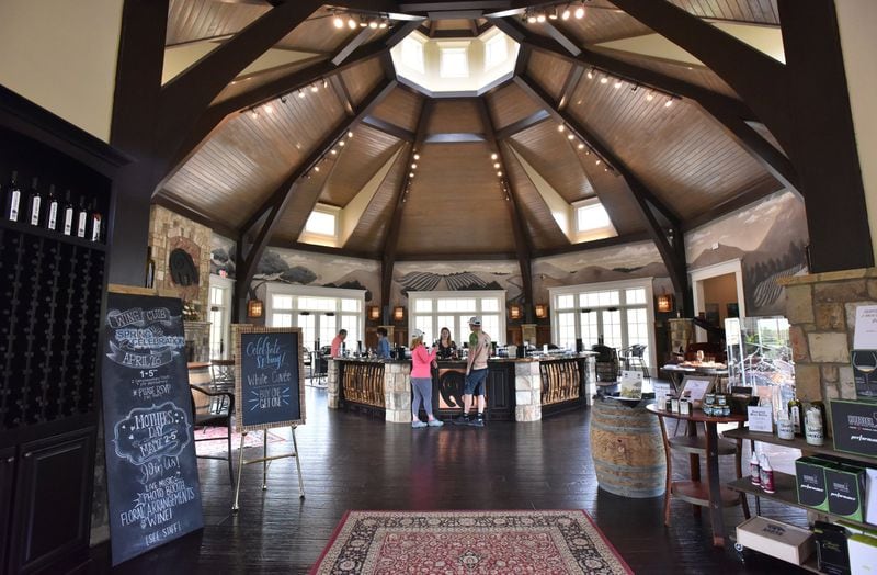 The tasting room at Yonah Mountain Vineyards has windows that look out onto the vineyards, as well as onto the solar panels that are helping provide energy for the winery. HYOSUB SHIN / HSHIN@AJC.COM