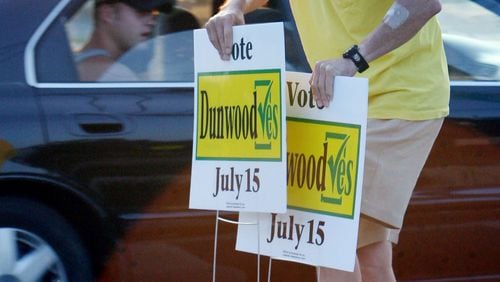 Ken Curry puts out pro-cityhood signs at the corner of Shallowford and Chamblee-Dunwoody roads before the community voted to incorporate as a city in July 2008.