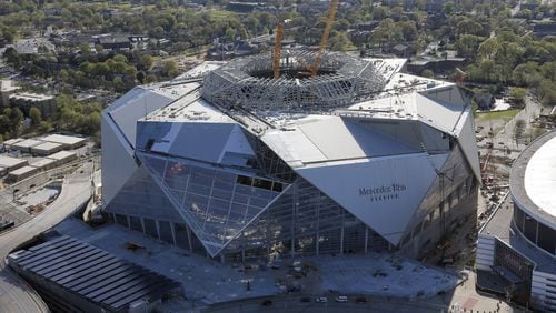 Mercedes-Benz Stadium sits next to the Georgia Dome. Aerial photo was taken last Friday. BOB ANDRES /BANDRES@AJC.COM