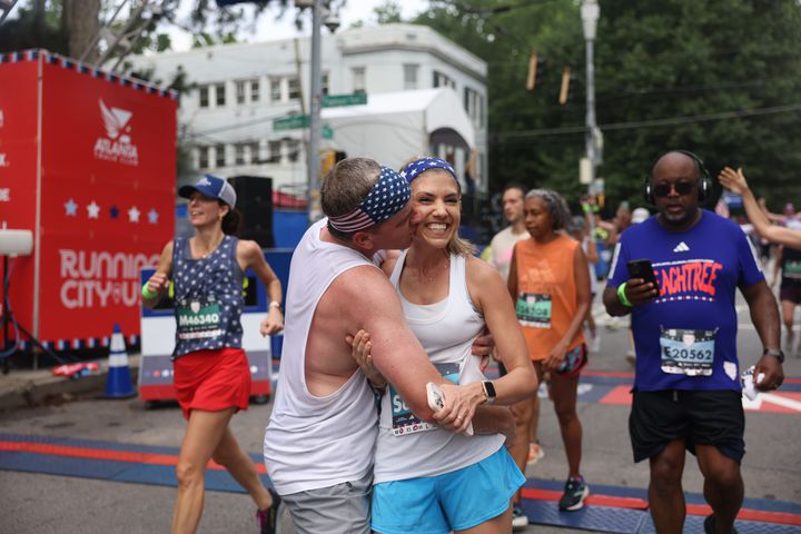 Runners celebrate at the finish of the 54th running of the Atlanta Journal-Constitution Peachtree Road Race in Atlanta on Tuesday, July 4, 2023.   (Jason Getz / Jason.Getz@ajc.com)