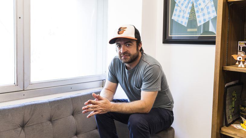 Derek Waters, the co-creator of Comedy Central’s “Drunk History,” in Los Angeles, Aug. 4, 2016. Waters loves going back to Baltimore to see family and friends; the Orioles cap can always be found in his carry-on. “I’m not a jock, I just love my town,” he said. (Emily Berl/The New York Times)