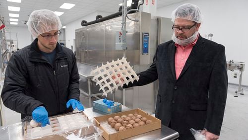 Keith Schroeder, right, founder and chief executive officer of High Road Ice Cream & Sorbet, and Grayson Shurett, left, a worker at High Road, examine ice cream scoops in High Road's factory in Marietta, Georgia (DAVID BARNES / SPECIAL)