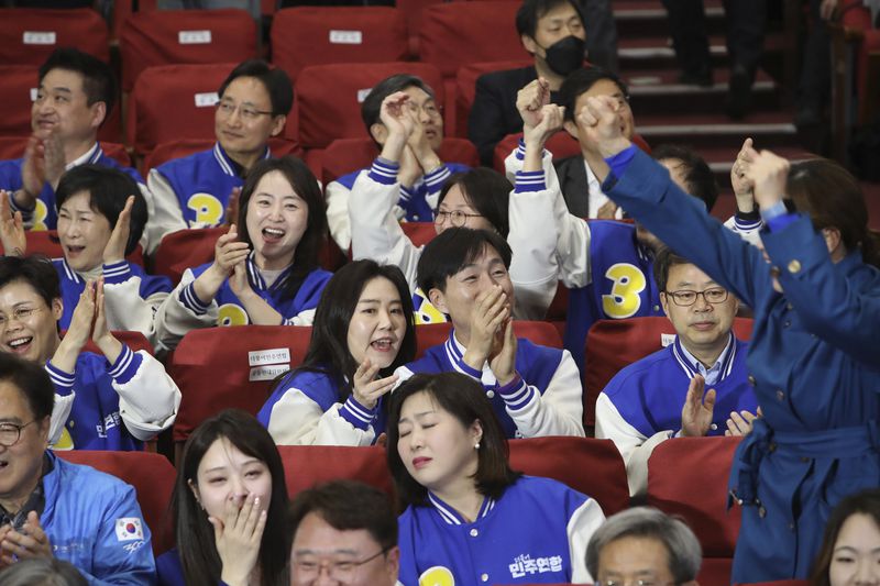 Candidates of Minjoo Union, an affiliated party of South Korea's main opposition Democratic Party, watch TV broadcasting results of exit polls for the parliamentary election at the National Assembly on Wednesday, April 10, 2024 in Seoul, South Korea. (Chung Sung-Jun/Pool Photos via AP)