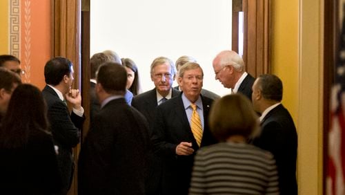 Senate Minority Leader Mitch McConnell, R-Ky., center, emerges from a closed-door meeting with Republican senators at the Capitol in Washington, Wednesday, Oct. 16, 2013. McConnell and his Democratic counterpart, Senate Majority Leader Harry Reid, D-Nev., reached last-minute agreement Wednesday to avert a threatened Treasury default and reopen the government after a partial, 16-day shutdown. Sen. Johnny Isakson, R-Ga., center right, speaks with Sen. Saxby Chambliss, R-Ga., right. (AP Photo/J. Scott Applewhite) Senate Minority Leader Mitch McConnell, R-Ky., center, emerges from a closed-door meeting with at the Capitol in Washington during the 2013 federal shutdown. Sen. Johnny Isakson, R-Ga., center right, speaks with then-Sen. Saxby Chambliss, R-Ga., right. AP/J. Scott Applewhite