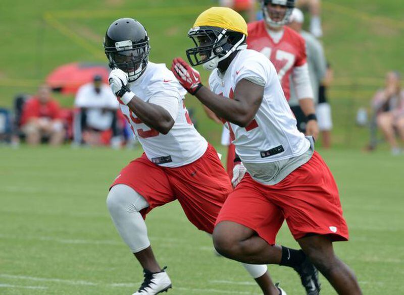 Falcons linebackers Joplo Bartu (59) and Yawin Smallwood (54) run through drills during the mini-camp. Atlanta Falcons players workout during the second day of mini-camp at the team's facilities in Flowery Branch, Wednesday, June 18, 2014. KENT D. JOHNSON/KDJOHNSON@AJC.COM