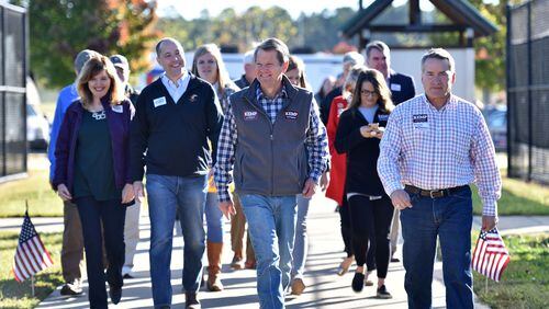 Brian Kemp (center) arrives at an event with other statewide Republican candidates and local elected officials. HYOSUB SHIN / HSHIN@AJC.COM