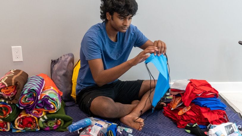 Akhil Kalva (age 15) fills "buddy packages" with clothes, toiletries and other items for children in foster care at his Johns Creek home. Phil Skinner for The Atlanta Journal-Constitution.