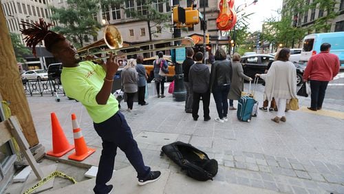 October 16, 2019 Atlanta: Street performer Eryk D. Radical, 26, a legally blind Georgia State University student, plays his trombone for pedestrians on Peachtree Street at Andrew Young International Boulevard in Atlanta. Radical is suing Atlanta police, MARTA police and the Fulton County Sheriff’s office alleging repeated harassment while playing on street corners. Curtis Compton/ccompton@ajc.com