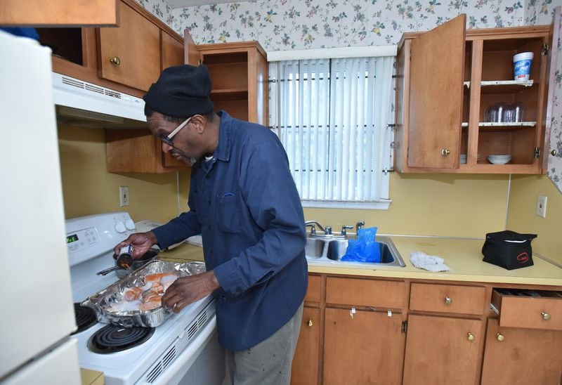 Byron Ferguson prepares a chicken dinner at his home in Columbus. After serving 11 terms in prison, Ferguson is serious about making a new life for himself on the outside. HYOSUB SHIN / HSHIN@AJC.COM