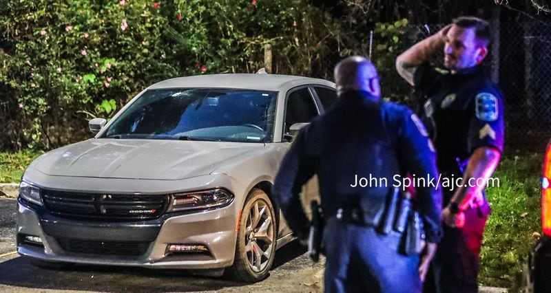 A gray Dodge Charger with a bullet hole in the windshield was towed from the scene of a shooting Tuesday morning that injured a Cobb County officer.
