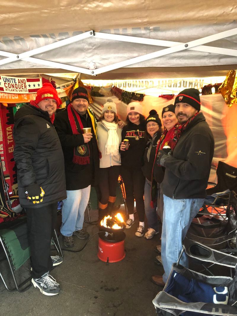 Kyle Yessa keeps warm with his tailgate crew at The Gulch before the Atlanta United game.