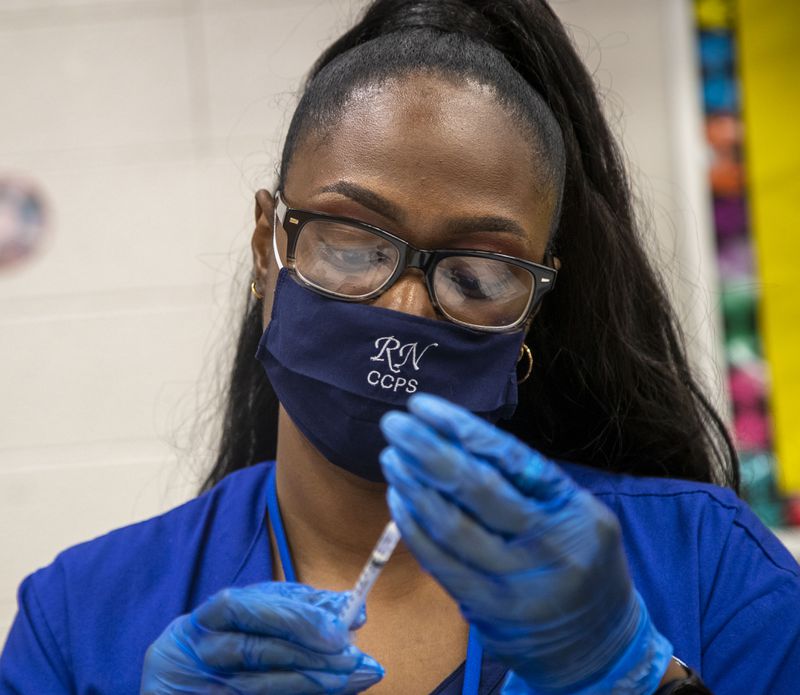 In this file photo, Clayton County Public Schools Nurse Supervisor Cynthia Pittman creates COVID-19 Pfizer vaccination shots during a Clayton County Public Schools COVID-19 vaccination and testing drive at G.P. Babb Middle School in Forest Park.  (Alyssa Pointer/Atlanta Journal Constitution)