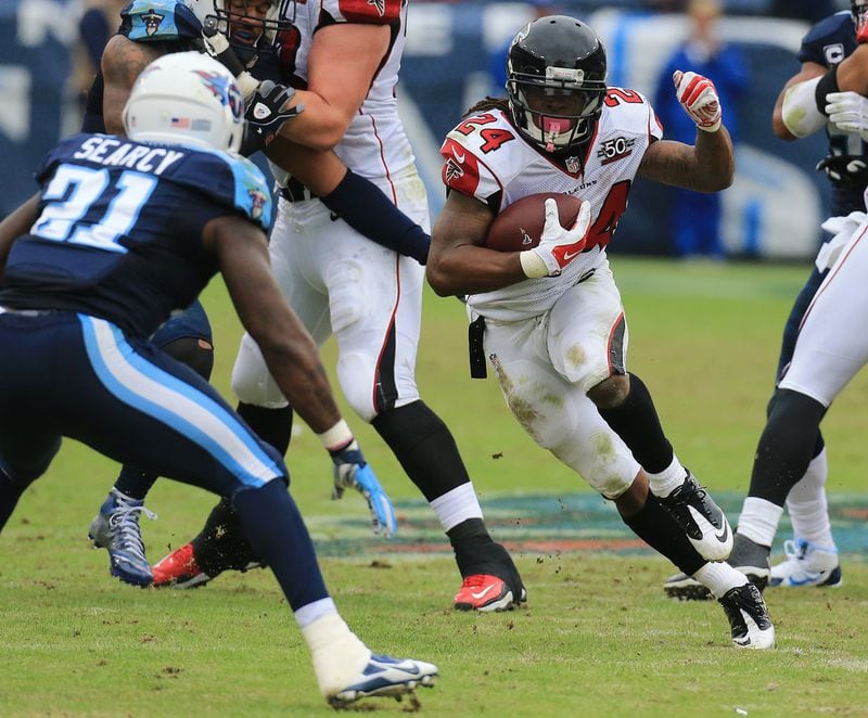 102515 NASHVILLE: -- Falcons running back Devonta Freeman finds some running room against Titans safety Da’ Norris Searcy during the first half in a football game on Sunday, Oct. 25, 2015, in Nashville. Curtis Compton / ccompton@ajc.com