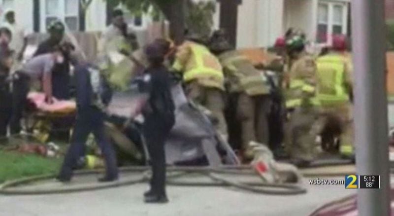 Cellphone video taken by bystanders shows Atlanta firefighters working to remove a father and his 3-month-old daughter from the mangled vehicle Monday.