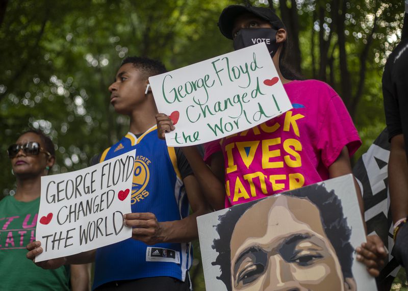 Activist Hannah Joy Gebresilassie, right, hold signs remembering George Floyd during a rally and march to Liberty Plaza outside of the Georgia State Capitol Building on May 25, 2021. Demonstrators paid tribute to George Floyd and other local people shot and killed in police-involved killings. (Alyssa Pointer / Alyssa.Pointer@ajc.com)
