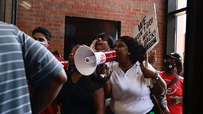 Eve Mayo, center with bullhorn, joined fellow residents of the Forest at Columbia Apartments and activists for a protest at the DeKalb County government complex Thursday. Residents said the complex's management company has told all tenants to be out by Aug. 31.