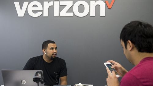 Verizon Wireless representative Edwin Segovia helps a customer at a Verizon Wireless store in Austin, Texas in February. NICK WAGNER / AMERICAN-STATESMAN