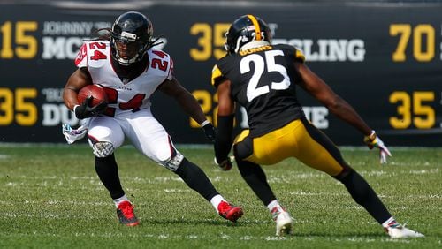 Devonta Freeman carries the ball against Artie Burns. (Photo by Justin K. Aller/Getty Images)
