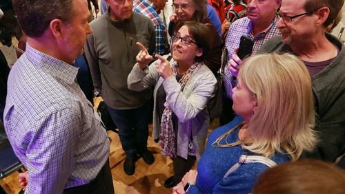 David Birdwell, a presenter who backs the proposed City of East Cobb, is confronted by Nancy Miller and other local residents with questions at the conclusion of a packed town hall meeting in Nolan Hall at the Catholic Church of St. Ann on Thursday, March 28, 2019, in Marietta.    Curtis Compton/ccompton@ajc.com