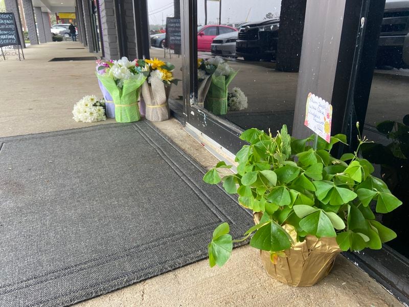 Mourners left flowers and a potted plant outside the Cherokee County spa where four people were shot to death on Tuesday.