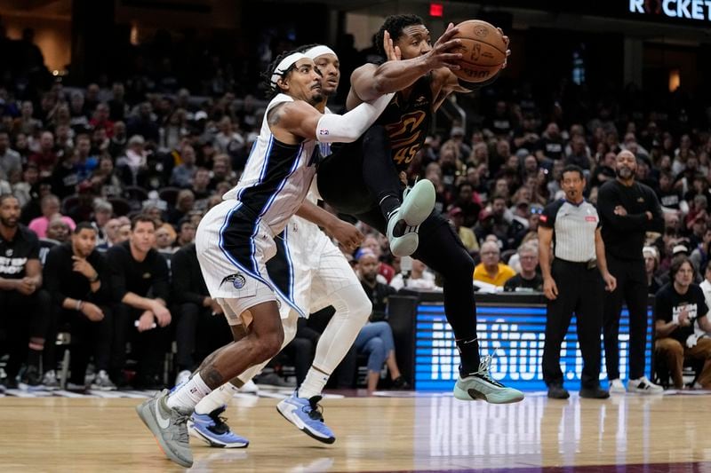 Cleveland Cavaliers guard Donovan Mitchell, right, grabs a rebound and is fouled by Orlando Magic guard Gary Harris, left, in the second half of Game 7 of an NBA basketball first-round playoff series, Sunday, May 5, 2024, in Cleveland. (AP Photo/Sue Ogrocki)
