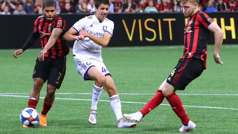 Atlanta United midfielder Julian Gressel scores an apparent goal past Orlando City defender Joao Moutinho with Josef Martinez looking on during the second half in a MLS soccer match on Sunday, May 12, 2019, in Atlanta. The goal was taken off the board after review, but Atlanta United held on to win the game 1-0. Curtis Compton/ccompton@ajc.com