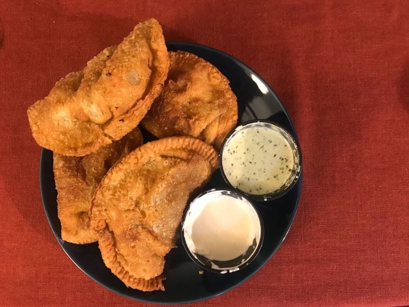 The empanada sampler at Papi’s Cuban Grill includes four hefty empanadas. Order the combo to try both the chicken and beef versions. LIGAYA FIGUERAS / LIGAYA.FIGUERAS@AJC.COM