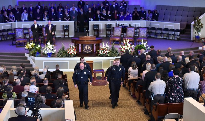 Officers carry the ashes of slain officer Chase Maddox during his funeral service Saturday.