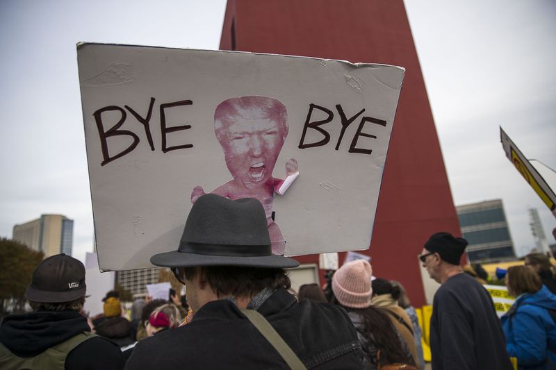 11/08/2019 -- Atlanta, Georgia -- An anti-Trump protestor holds a protest sign during a rally outside of the Georgia World Congress Center in downtown Atlanta, Friday, November 8, 2019. President Trump was in Atlanta on Friday to speak to a crowd of African American voters that support his presidency. (Alyssa Pointer/Atlanta Journal Constitution)