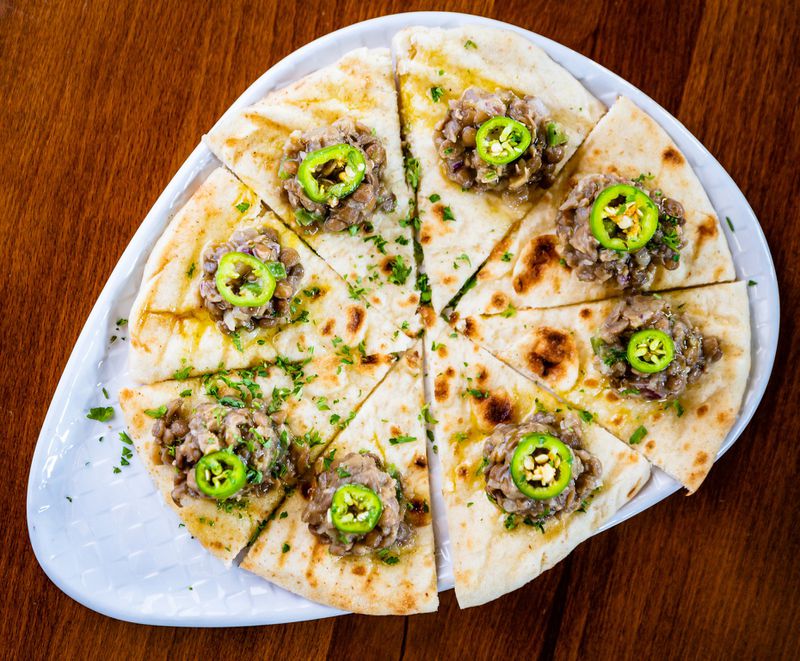 Azifah is an appetizer of well-seasoned brown lentils, topped with sliced jalapeno, on pita bread at Feedel Bistro. CONTRIBUTED BY HENRI HOLLIS