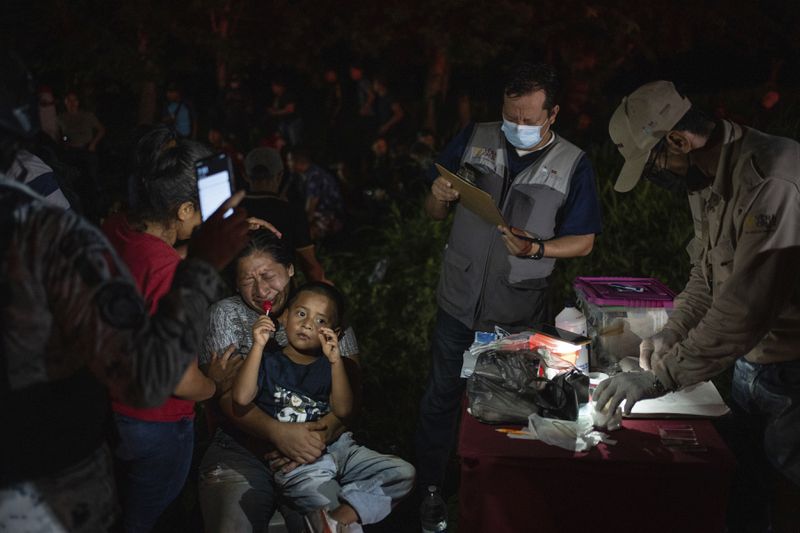 Migrants, mainly from Central America, who were traveling to the U.S. inside a tractor-trailer, are detained by Mexican immigration agents and National Guard members, in Veracruz, Mexico, Sunday, July 23, 2023. The image was part of a series by Associated Press photographers Ivan Valencia, Eduardo Verdugo, Felix Marquez, Marco Ugarte Fernando Llano, Eric Gay, Gregory Bull and Christian Chavez that won the 2024 Pulitzer Prize for feature photography. (AP Photo/Felix Marquez)