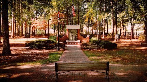 Photo illustration depicts memorials to armed forces service members and their families on either side of the Faces of War Memorial on the grounds of Roswell City Hall. CITY OF ROSWELL