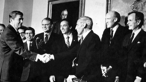 FILE — After signing the Immigration Reform and Control Act, President Ronald Reagan, left, shakes hands with Rep. Romano Mazzoli (D-Ky.), an architect of the legislation, at the White House on Nov. 6, 1986. Mazzoli, the son of an Italian immigrant who as a Democratic representative teamed up with a conservative senator from Wyoming to champion the last major attempt at comprehensive immigration reform, died on Nov. 1, 2022, at his home in Louisville, Ky. He was 89. (Paul Hosefros/The New York Times)