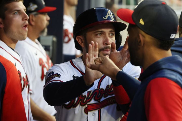 Atlanta Braves catcher Travis d'Arnaud gets high-fives at the Braves dugout after scoring the first run in the second inning at Truist Park. Tuesday, April 12, 2022. Miguel Martinez/miguel.martinezjimenez@ajc.com