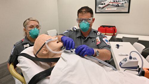 Rob Bozicevich, an EMS Academy manager, demonstrates a high-flow nasal cannula device on a patient simulator as paramedic student Devin Drinkwater watches, at the Metro Atlanta Ambulance Service in Marietta. The pandemic has changed the way emergency crews work. Now, EMS workers are adapting to the need to treat more patients with respiratory distress, etc. (Hyosub Shin / Hyosub.Shin@ajc.com)
