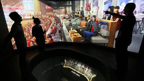 Arpan Patel (from left), Addison Nunes and Aaron Coffey, working “The Pit” feature in the Philips Arena preview center, run a projection of the Atlanta Social area, one of the changes coming to the arena in the fall.