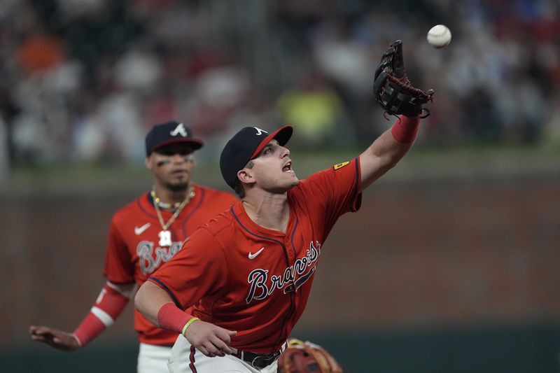 Atlanta Braves third base Austin Riley (27) catches a fly ball to retire Texas Rangers' Josh Smith in the fifth inning of a baseball game Friday, April 19, 2024, in Atlanta. (AP Photo/John Bazemore)
