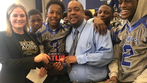 Brown Middle School teacher and football coach Ernest Davis, in blue shirt and tie, found out Friday he had won a ticket to the Super Bowl, to be played Feb. 3 in Atlanta.