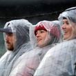 Three Atlanta Braves fans from Macon, Ga., sit through a steady during the seventh inning of Monday's Braves-White Sox matchup in Chicago. The Braves beat the White Sox, 9-0, in a game that was officially called after eight innings because of rain. (AP Photo/Charles Rex Arbogast)
