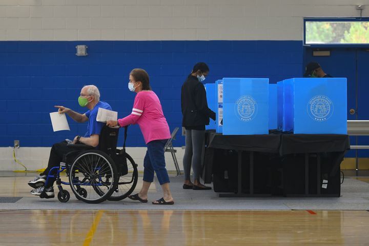 Robert Jones points to the ballot box as his wife Shelba pushes his wheelchair after they made their voting selections as the first day of early voting gets underway on Monday, Oct. 12, 2020, at the George Pierce Park  in Suwanee, Ga. JOHN AMIS FOR THE ATLANTA JOURNAL- CONSTITUTION