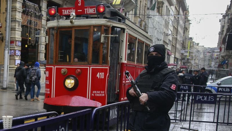 In this Thursday, Jan. 5, 2017 photo, a  tram is driven past as a Turkish police officer secures central Istanbul's Istiklal Avenue, the main shopping road of Istanbul. Turkey's economy is suffering in the face of a string of extremist attacks _ including the nightclub massacre of New Yearâs revelers, most of them foreigners _ and uncertainty following the failed coup in July against President Recep Tayyip Erdogan that saw more than 270 people killed. (AP Photo/ Emrah Gurel)