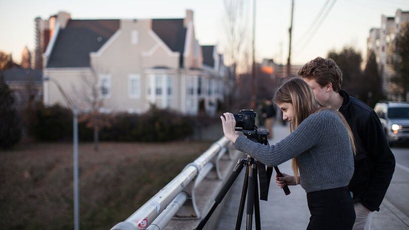 Sydney Lord, left, and her brother Sam Lord record video footage of the Atlanta skyline from the Jackson Street Bridge at sunset, Wednesday, Jan. 28, 2015, in Atlanta. Experienced local photographers may consider the view from the bridge a little cliche, but that doesn’t stop them from returning to it for a better shot. (SPECIAL/BRANDEN CAMP)