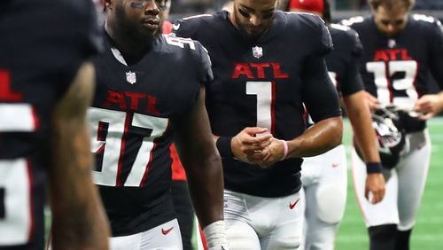 Falcons defensive lineman Grady Jarrett and quarterback Marcus Mariota walk off the field dejected after falling in a 27-26 heartbreaker to the Saints on Sunday in Atlanta. (Curtis Compton / Curtis Compton@ajc.com)