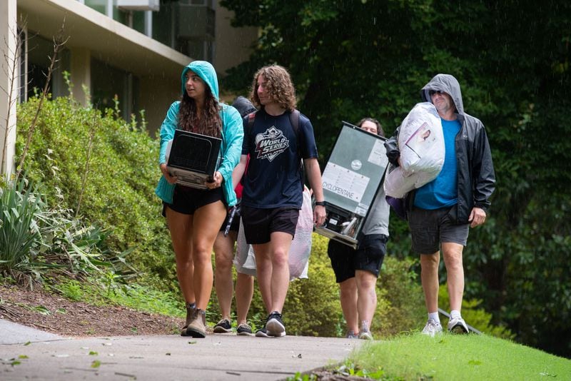 A group of students and parents walks to the entrance of Boggs Hall with dorm furnishings on Monday, Aug. 16, 2021 on the University of Georgia's Campus in Athens, Georgia. Move in commenced on Friday, Aug. 13 ahead of the start of classes on Wednesday, Aug. 18. (Julian Alexander for the Atlanta Journal-Constitution)