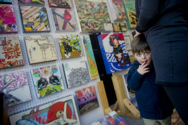 Cade Green (left) holds onto his mother Marlene as she looks at the Urban Attic booth during the 9th Annual Brookhaven Arts Festival on Saturday, Oct. 20, 2012.