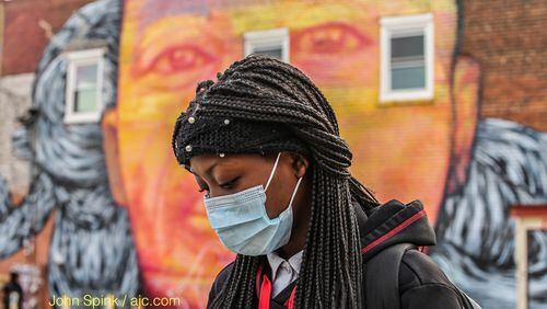 Jacara Jackson, 14, wears a mask because of pollen as she waits for the school bus in the 400 block of Edgewood Avenue on Thursday. JOHN SPINK / JSPINK@AJC.COM