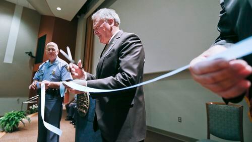 September 18, 2012: DPS Commissioner, Colonel Mark McDonough (left) holds the ribbon as Georgia Governor Nathan Deal cuts through (right). A ceremony and ribbon cutting was held Tuesday, Sept 18, 2012 at the new offices of the Georgia Department of Public Safety for the Georgia State Patrol Post 50, Capitol Hill Capitol Police Division and the Motor Carrier Compliance Division that are now housed in the former Capitol Education Center at 180 Central Avenue across from the State Capitol. Governor Nathan Deal along with GSP Colonel Mark McDonough and State Property Officer Steve Stancil officially cut the ribbon following remarks by all three men. Several troopers and state law enforcement officers were on hand in the facility’s auditorium where the event was held due to inclement weather. JOHN SPINK / JSPINK@AJC.COM Jason Carter claims the economic development office has been politicized.