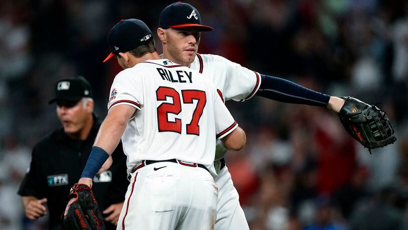 Braves infielders Freddie Freeman (background) and Austin Riley celebrate after the Braves defeated the San Diego Padres Tuesday, July 20, 2021, at Truist Park in Atlanta. (John Bazemore/AP)