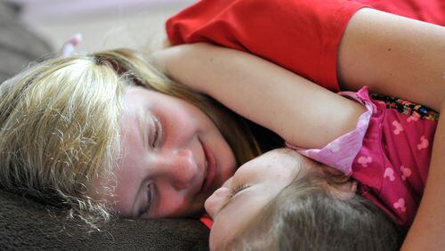 Marlee Anne Hopkins, 12, comforts her sister, Mary Elizabeth, at their home in Covington. Kelli and Mike Hopkins had three special-needs children who suffer from a seizure disorder that could be treated by a cannabis-based oil. Their 6-year-old son Abe passed away at the end of July when he had a seizure and stopped breathing. HYOSUB SHIN / HSHIN@AJC.COM